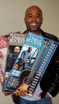 a man is holding several dvds in his hands and smiling at the camera while wearing a leather jacket