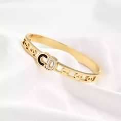 Introducing the Luxe Monogram Elegance Bangle, a synergy of classic style and contemporary elegance. Meticulously crafted to perfection, this striking piece boasts an intricate monogrammed centerpiece that speaks of a distinctive personality. Choose between luxurious gold and striking silver to express yourself with an effortless finesse. Wear it solo for a resplendent statement or layer it up for an elevated look—this bangle is certain to bring your wristwear look to new heights and demonstrate Gold Bangles, Jewelry Care, Rhodium Plated, Classic Style, Personal Style, 18k Gold, Bangles, Monogram, Silver