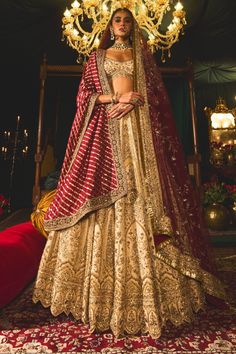 Step into refined elegance with this opulent gold lehenga, a stunning embodiment of artistry and tradition. Crafted from rich raw silk, the lehenga features intricate filigree work that gracefully dances across the fabric like golden vines. Hand-embroidered with vintage gold zari and shimmering sequins, the blouse and lehenga skirt showcase a beautiful romance depicted through floral and bird motifs. Paired with a striking maroon dupatta adorned with a delicate kiran border, this ensemble captures the essence of timeless beauty, making it perfect for any grand occasion. Maroon Dupatta, Gold Lehenga, Lehenga Skirt, Bird Motif, Gold Fabric, Raw Silk, Diwali, Timeless Beauty, Vintage Gold