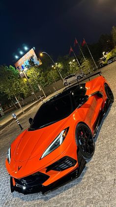 an orange sports car is parked on the street