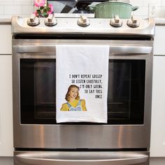 a tea towel hanging on an oven door with the words, i don't really care