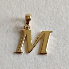 This is an exquisite initial charm pendant set in 14K Solid Gold.  An elegant design, perfect for any occassion. ITEM DETAILS: ✓ Letter : M ✓ Gold Kt: Solid 14K Yellow Gold ✓ 14 K Gold Weight : 1.51 grams ✓ Gross Weight: 1.51 grams >>The Gold purity is guaranteed and it comes with authentic 14K gold hallmark. >>A-Z letters available on my Etsy Shop. CUSTOMER SUPPORT: We are available 24/7 to respond to all your queries! PACKAGING: The pendant comes in layers of safe and secure wrapping along with a free Handmade Jewelry Box. Classic Formal Initial Necklace, Classic Yellow Gold Initial Necklace For Mother's Day, Classic Initial Necklace For Anniversary And Mother's Day, Mother's Day Yellow Gold Classic Initial Necklace, Mother's Day Classic Yellow Gold Initial Necklace, Classic Initial Necklace For Mother's Day, Classic Pendant Initial Necklace, Anniversary Initial Pendant Necklace With Polished Finish, Elegant Hallmarked Initial Pendant Necklace