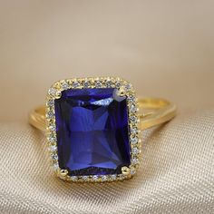 An Exquisite Blue Sapphire ring Halo set with diamonds.Flaunting as large impressive blue sapphire set in a high basket shimmer presence and luxury.Stand out wherever you go with this luxurious piece.It could be a wonderful engagement ring or a a luxurious fine piece of jewelry to wear on that special evening.Each gemstone is handpicked and inspected for the best color and clarity, The ring is beautifully finished and ready to give as a gift.• Made to Order, beautifully finished, Fully insured w Blue Emerald-cut Diamond Ring With Birthstone, Blue Emerald Cut Diamond Ring With Birthstone, Formal Blue Diamond Ring With Birthstone, Blue Birthstone Diamond Ring For Formal Occasions, Formal Blue Diamond Ring With Halo, Formal Blue Birthstone Diamond Ring, Formal Sapphire Halo Ring With Cubic Zirconia, Formal Sapphire Crystal Ring With Halo Setting, Blue Cubic Zirconia Diamond Ring With Halo Design