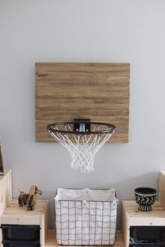 a basketball hoop mounted to the side of a wall above a basket in a living room