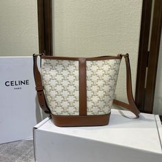 The body pattern of the Celine Small bucket bag is dominated by the Arc de Triomphe buckle logo and is surrounded by brown cowhide to create retro elements. The retro color system is suitable for winter with a coat. It has a large capacity and light weight. Wear-resistant waterproof not easy to scratch. White & Tan. Triomphe logo prints. Canvas & Smooth Calfskin Leather. Fabric Lining. Gold toned hardware. Snap button Closure. Waterproof. Shoulder & Crossbody Carry. Adjusta... Celine Small Bucket Bag, Retro Elements, Body Pattern, Small Bucket Bag, Luxury Clutch, Small Buckets, Brown Cowhide, Hot Bags, Celine Bags