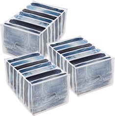 four clear plastic storage boxes with blue and white striped designs on the sides, each containing six pairs of pants