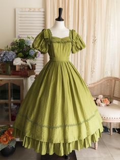 This price includes a dress and a green bowknot hairclip (not for sale).  Embrace timeless elegance with this enchanting Olive Green Puff Sleeves Classic Lolita Princess Tea-Length Dress. Designed for the true Lolita aficionado, this dress features delicately puffed sleeves and a flattering tea-length skirt that exudes sophistication and charm. The back boasts a comfortable shirring detail, ensuring a perfect fit for all body types. Whether you're attending a tea party, a cosplay event, or simpl Green Puff Sleeve Dress For Wedding, Green Puff Sleeve Dress In Cottagecore Style, Green Cottagecore Dress With Ruffles, Green Vintage Dress With Ruffles For Garden Party, Green Vintage Victorian Dress With Ruffles, Green Ruffled Vintage Dress, Green Vintage Dress With Ruffles, Vintage Green Puff Sleeve Dress, Vintage Green Dress With Puff Sleeves