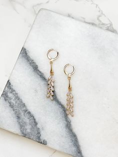 Add a touch of glam to your look with our Gold Huggie Hoop Crystal Drop Earrings. These elegant earrings feature a glitzy dangle design that will catch the light and add sparkle to any outfit. Perfect for a night out or a special occasion, these earrings are sure to make a statement. 0.75"L Lead & Nickel Compliant Party Dangle Huggie Earrings, Sparkling Stones Drop Earrings, Glamorous Small Hoop Cubic Zirconia Earrings, Sparkling Dangle Hoop Earrings With Cubic Zirconia, Sparkling Cubic Zirconia Dangle Hoop Earrings, Party Huggie Dangle Earrings, Small Hoop Earrings With Sparkling Stones For Party, Sparkling Stones Small Hoop Earrings For Party, Cubic Zirconia Huggie Earrings For Party