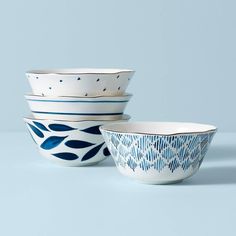 three bowls with blue designs on them sitting side by side in front of a light blue background