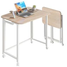 a laptop computer sitting on top of a wooden desk next to a white metal frame