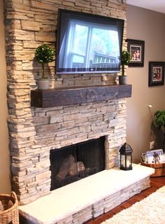 a living room with a fireplace and tv mounted on the wall above it's mantle