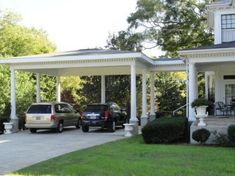 two cars are parked in front of a white house with pillars and columns on the porch