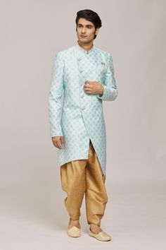 Firozi asymmetric sherwani with woven floral patterns. Comes with dhoti pant.
Components: 2
Pattern: Woven
Type Of Work: Floral
Neckline: Mandarin Collar
Sleeve Type: Full
Fabric: Sherwani: Mercury Jacquard Churidar: Silk Dupion
Color: Blue
Other Details: 
Embellished buttons
Closure:
Sherwani: Front button
Dhoti pant: Drawstring
Note: Pocket square worn by the model is not for sale
Occasion: Sangeet,Mehendi and Puja - Aza Fashions Sherwani With Dhoti, Dhoti Pants For Men, Blue Sherwani, Embellished Buttons, Dhoti Pants, Churidar, Floral Patterns, Mandarin Collar, Pocket Square