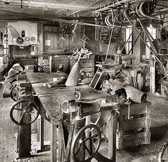 an old black and white photo of some machinery in a room with lots of wood