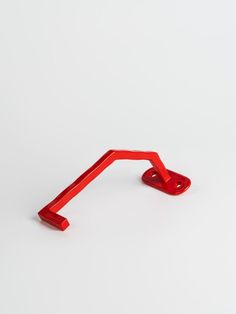 a red plastic object sitting on top of a white surface