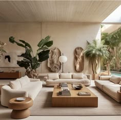 a living room filled with lots of furniture next to a swimming pool and palm trees