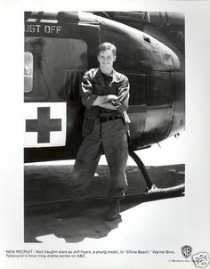 black and white photograph of a man standing in front of an air force plane with his arms crossed