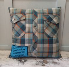 a blue and white plaid pillow sitting on top of a wooden table