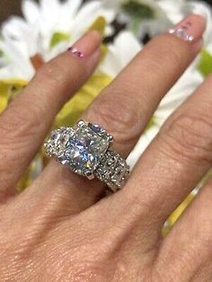 a woman's hand with two diamond rings on it