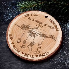 personalized christmas ornament for the family of four on a wood slice with pine needles