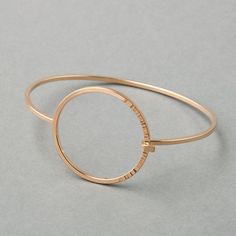 A high-polish bangle made with square wire bands, featuring a circular closure with a hammered texture one third of the way around. - Tension-connection closure- Circle measures 1 ¼” wide- 2mm thick bandSequence Collection Modern Hammered Bangle Bracelets, Modern Hammered Metal Bracelets, Modern Rose Gold Bangle, Modern Rose Gold Round Bangle, Modern Hammered Yellow Gold Bracelets, Modern Hammered Yellow Gold Bangle, Modern Hammered Bangle, Modern 14k Gold Hoop Bracelets, Modern Hammered Bangle For Formal Occasions