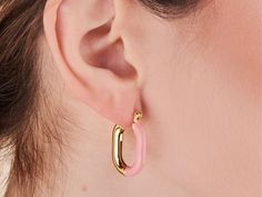 A fun take on the classic hoop. These hoops pair pink enamel and brilliant gold into one must-have design. Wear solo or style with refined studs for a sleek finish. 14k gold plated over brass. Hoop dimension: 18mm x 24mm Hypoallergenic, nickel and lead free Tarnish resistant Chic Pink Small Hoop Earrings, Small Hoop Pink Metal Earrings, Pink Enamel Dainty Jewelry, Small Hoop Enamel Earrings, Pink Enamel Hoop Earrings, Pink Enamel, Gold Plate, Plating, Sleek