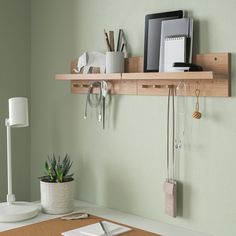 a wooden shelf with key hooks and other items on it