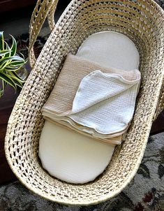 a wicker basket with folded napkins and a potted plant in the background