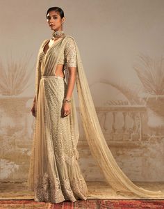 Step into sophistication with this silver green persian embroidered sari set – a perfect harmony of tradition and contemporary flair. This stunning ensemble features a pre-draped sari and drape blouse, intricately embroidered in silver green motifs. The striking color and persian-inspired design add a regal touch, making it an ideal choice for special occasions. Floor-length Pre-draped Saree With Dupatta, Transitional Tissue Silk Pre-draped Saree For Reception, Traditional Wear With Sheer Dupatta, Traditional Wear Saree With Sheer Dupatta For Reception, Traditional Saree For Reception With Sheer Dupatta, Pre-draped Tissue Silk Saree With Sheer Dupatta For Reception, Pista Green Traditional Draped Sharara For Reception, Traditional Embellished Pre-draped Saree In Raw Silk, Pista Green Sharara For Reception With Traditional Drape