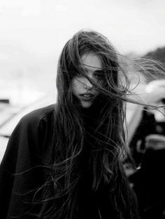 a black and white photo of a woman with long hair