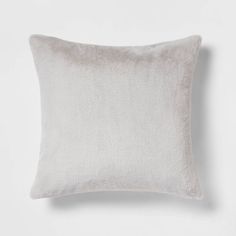 a white pillow that is sitting on top of a table and it has a light gray background