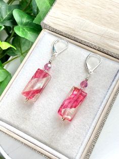 Pretty in pink! Rectangle Murano glass beads are shimmering with pink and genuine sterling silver foil. A Swarovski crystal in pink accents the glass bead in a great shine as well! The beads hang on Sterling silver lever back ear wires for perfect comfort and security. The earrings hang 2 inches. A wonderful gift for any occasion and arrives in a standard gift box. ✨ Authentic Murano Glass: Each pair of earrings showcases the unparalleled beauty of Murano glass, renowned for its vibrant colors a Czech Glass Rectangular Earrings For Gift, Rectangular Czech Glass Earrings For Gifts, Pink Dangle Crystal Earrings For Gift, Czech Glass Earrings As A Gift, Handmade Pink Crystal Sterling Silver Earrings, Handmade Pink Crystal Earrings In Sterling Silver, Elegant Pink Czech Glass Earrings, Handmade Pink Glass Jewelry, Gift Crystal Earrings With Czech Glass