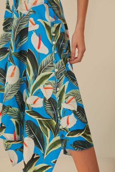 Step into a tropical oasis with the Blue Anthurium Garden Asymmetric Midi Skirt by FARM Rio. A vision in azure, this piece blooms with lush anthuriums and verdant foliage, creating a vibrant print that captivates and charms. The midi skirt flutters with an asymmetric hemline, adding a playful twist to your every move, while the high-waisted silhouette gracefully flatters the form. Embody the spirit of summer days and let this unique skirt speak to your penchant for daring elegance and joyful fashion narratives. Composition 100% COTTONCare Instructions MACHINE WASH GENTLE CYCLE, DO NOT BLEACH, DO NOT TUMBLE DRY, LINE DRYING, IRON AT LOW HEAT, DRY CLEAN WITH ANY SOLVENT EXCEPT TRICHLOROETHYLENESize and Fit Inches XXS XS S M L XL Bust N/A N/A N/A N/A N/A N/A Waist 24 3/4 26 3/4 28 3/4 30 3/4 Blue Anthurium, Anthurium Garden, Unique Skirt, Unique Skirts, Tropical Oasis, Farm Rio, Summer Days, Lush, Midi Skirt