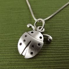 "This pretty little ladybug is made of sterling silver. The pendant is TINY, measuring about 1/2\" (1.2 cm) in length.  Super cute! You can purchase just the pendant/charm, or complete the necklace with a sterling silver chain.  For the matching ladybug earrings:  www.etsy.com/listing/228278367/tiny-ladybug-earrings © Stick Man Creations This is our own original design, handcrafted by us, and signed on the back with our logo.   If you want to read more about the process, click here:  www.etsy.co Cute Silver Pendant Charm Necklace, Cute Silver Sterling Silver Charm Necklaces, Cute Sterling Silver Pendant Charm Necklaces, Cute Sterling Silver Pendant Charm Necklace, Cute Silver Charm Necklaces With Lobster Clasp, Small Sterling Silver Charm Necklace, Cute Nickel-free Sterling Silver Necklaces, Cute Silver Charm Necklaces, Cute Round Silver Necklace