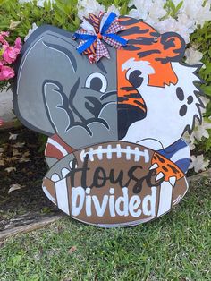 a yard sign with an elephant, tiger and football on it that says house divided