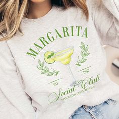 Elevate your style with the Margarita Social Club Crew Sweatshirt, a chic tribute to laid-back sophistication. Featuring a vivid margarita glass design, this exclusive sweatshirt is available in trendy colors: white, pink, ash, and ivory. Embrace comfort and fashion with this versatile piece, perfect for casual outings or stylish social gatherings. Crafted for year-round wear, the Margarita Social Club Crew Sweatshirt blends iconic imagery with a contemporary aesthetic, making it a must-have for those who appreciate the finer things in life. Cheers to style and leisure! Design is Printed Direct to Garment. See Size Guide for Unisex Crew Sweatshirt in photos We recommend comparing these measurements against a sweatshirt that you like the fit of for ordering a sweatshirt that will fit best. Graphic Desi, Cocktail Club, Plus Size Shopping, Social Club, Crew Sweatshirts, Caicos Islands, Trendy Colors, Turks And Caicos Islands, Glass Design