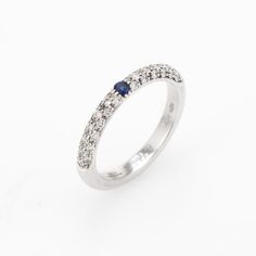 Elegant Adolfo Courrier stacking ring, crafted in 18 karat white gold.   One estimated 0.05 carat sapphire, accented with 36 estimated 0.01 carat round brilliant cut diamonds totaling an estimated 0.36 carats (estimated at G-H colour and VS2 clarity).    The house of Adolfo Courrier is a highly regarded Italian jeweller known for a brilliant contrast of colour and texture. The clean contemporary design of the ring is great worn alone as a simple band or stacked with your other rings.  The ring i Classic Sapphire Ring With Pave Setting, Modern Sapphire Ring With Single Cut Diamonds For Anniversary, Brilliant Cut Sapphire Diamond Ring, Sapphire Rings With Diamond Accents And Round Cut, Sapphire Diamond Ring With Brilliant Cut, Diamond Ring With Brilliant Cut Sapphire In Round Shape, Formal Sapphire Diamond Ring With Single Cut Diamonds, Classic Sapphire Rings With Pave Setting, Timeless White Gold Stackable Rings With Pave Setting