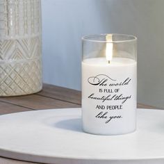 a white candle sitting on top of a wooden table