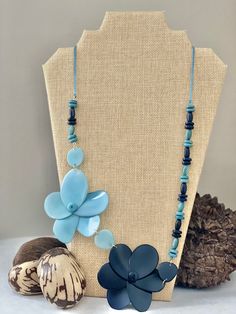 Handmade in Ecuador Necklace Length: 28 Inches Material: Tagua Nut Gold Handmade Clasp Due to this item being handmade and the nature of the Tagua Nut the size and the color may vary from piece to piece Bohemian Blue Flower Necklace, Handmade Blue Flower Beaded Necklaces, Handmade Blue Flower Beaded Necklace, Handmade Blue Necklaces For Beach, Handmade Blue Necklaces For The Beach, Blue Flower Shaped Beaded Necklace For Gift, Blue Flower-shaped Beaded Necklace Gift, Blue Adjustable Flower Necklace, Blue Flower-shaped Jewelry For The Beach