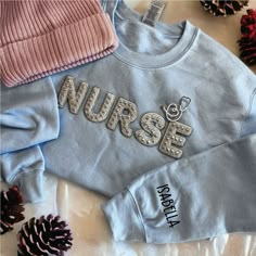 Custom Nurse Sweatshirt with  Name on the Sleeve and Stethoscope Brooch  IMPORTANT NOTE Please make sure to CHECK YOUR Email Or your Etsy Conversations after you placed an order until you receive your package in case we have a question regarding your order! The use of the messaging system is very easy and convenient and you can always expect a timely reply during business days/hours. We are not responsible for packages that do not make it in time of your event if you did not give us a "Date Need New Grad Nurse Essentials, Nurse Sweatshirt Ideas, Nurse Graduation Cap Designs, Gifts For Nursing Students, Nurse Gear, Nursing Motivation, College Job, Nursing Pins, Christmas Gifts For Nurses