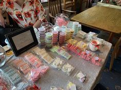 a woman sitting at a table covered in candy and candies with a framed photo