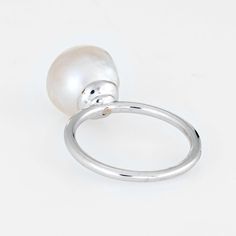 Finely detailed estate cultured pearl & diamond ring, crafted in 14 karat white gold.   The cultured pearl measures 10mm with a diamond inset into the pearl (estimated at 0.05 carats - H-I colour/VS2 clarity). The stones are in excellent condition and free of cracks or crisps.   The stylish high rising ring features a gemstone-in-gemstone design. The diamond is artfully bezel set into the pearl for a striking and unusual look . A great ring to wear alone or stacked with your fine jewellery from White Pearl Drop Ring For Formal Occasions, Formal White Pearl Ring, Classic White Pearl Ring With Charm, Classic White Gold Pearl Drop Ring, Classic White Pearl Ring With Pearl Charm, Classic White Gold Pearl Ring With Pearl Drop, White Akoya Pearl Timeless Ring, Timeless White Akoya Pearl Ring, Classic White Pearl Ring With Drop Detail