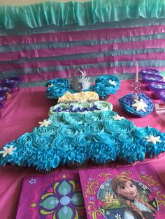 the table is set up with cupcakes and cakes for a frozen princess birthday party