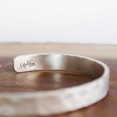 Hammered Silver Cuff 1/4" This Hammered Silver Cuff shines with the allure of a sunlit peak. Its versatility makes it perfect for everyday wear, enhancing any ensemble with a touch of understated sophistication.It's more than just adornment; it's a canvas for your personal story. With the option to personalize it, you can engrave a secret message, a cherished mantra, or a reminder of your own strength – keeping it close to your wrist as a source of inspiration. Let the Hammered Silver Cuff Brace Engraved Adjustable Sterling Silver Cuff Bracelet, Engraved Sterling Silver Adjustable Cuff Bracelet, Adjustable Sterling Silver Stamped Cuff Bracelet, Elegant Adjustable Stamped Cuff Bracelet, Classic Adjustable Stamped Cuff Bracelet, Classic Stamped Adjustable Cuff Bracelet, Adjustable Cuff Jewelry For Everyday, Minimalist Stackable Cuff Bracelet For Anniversary, Adjustable Stamped Sterling Silver Bangle