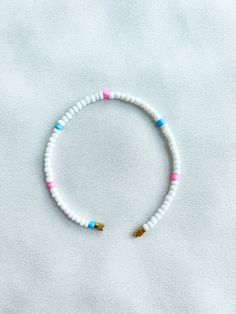 Handcrafted white beaded anklet/bracelet with pink and blue details. Made using large colourful round glass beads and finished with a gold-plated barrel clasp closure. Pair it with our matching Necklace.  * Weight: 7g   * Width: 5mm/2mm  * Made in UK  * Code: 111AWPBL The very best in unique, handmade pieces from BAM-BAM, our anklets and bracelets make great accessories for the beach, festival or club. These large beads have a bold appearance and can take your best looks from day to night. White Beaded Necklaces With Heart Beads For Beach, White Beaded Necklace With Heart Beads, White Heart Beads Necklace For Beach, White Beaded Strand Anklet, White Beaded Necklace With Heart Beads For Beach, White Round Bead Anklets For Summer, White Round Beads Anklet For Summer, White Jewelry With Letter Beads For Vacation, White Heishi Beads Friendship Bracelets For Vacation