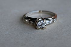 a close up of a ring with a diamond on the top and two bands around it