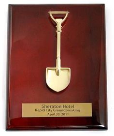 an award plaque with a shovel in it on a white background for the sheraton hotel rapid city ground breaking