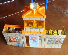 an orange and white toy house on the floor