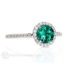 an emerald and diamond ring on a white background