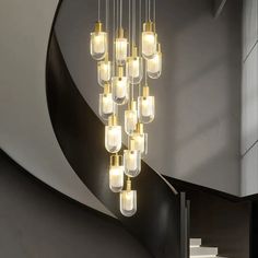 a modern chandelier hanging from the ceiling in a room with black and white walls